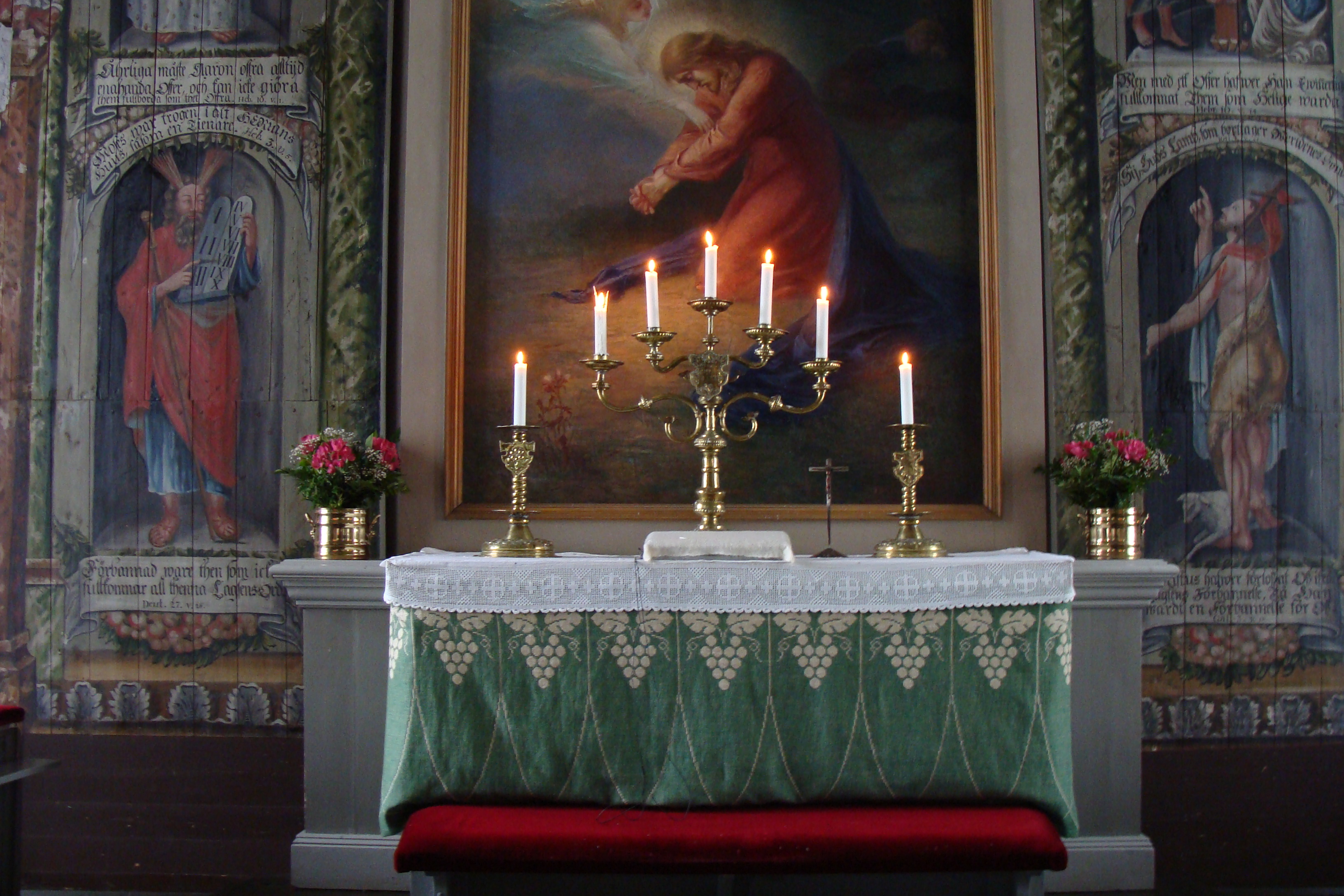 Kaarlelan kirkon alttarilla palaa kynttilöitä.