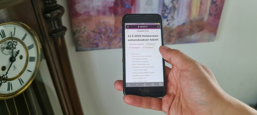Kädessä olevassa kännykässä on ruudulla Raamattu.fi -rukouspalvelu.
