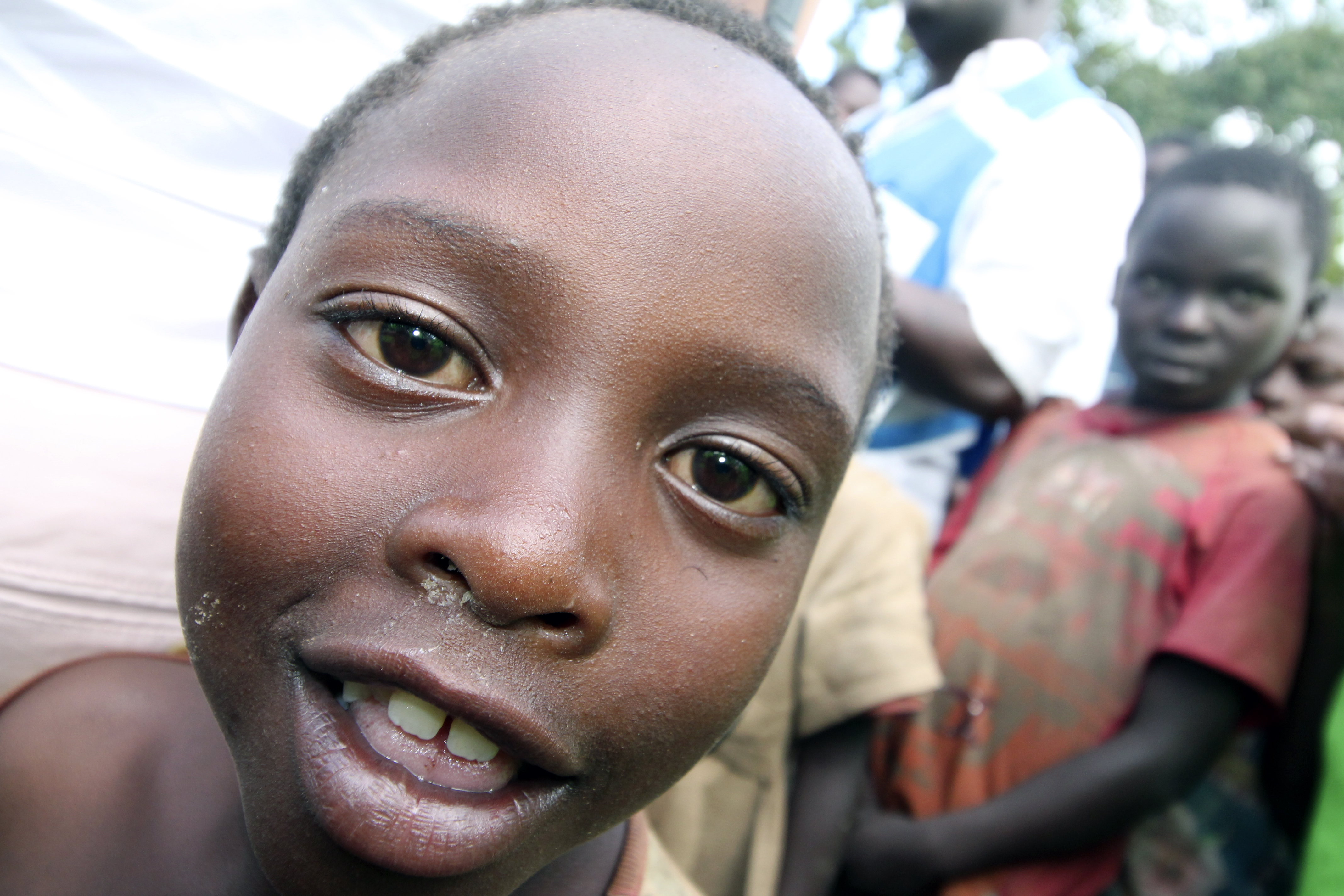 Pakolaislapsi Ugandassa oli kiinnostunut kameran linssistä. Kuva Martti Komu.