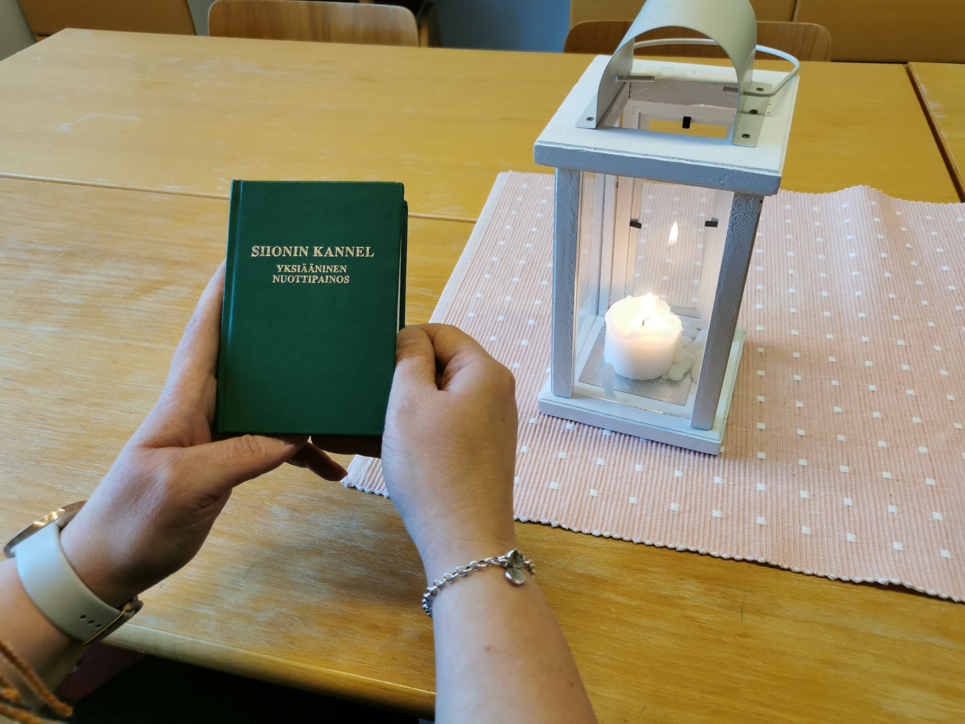 Ihminen pitää vihreää SIonin kannelta käsissään.