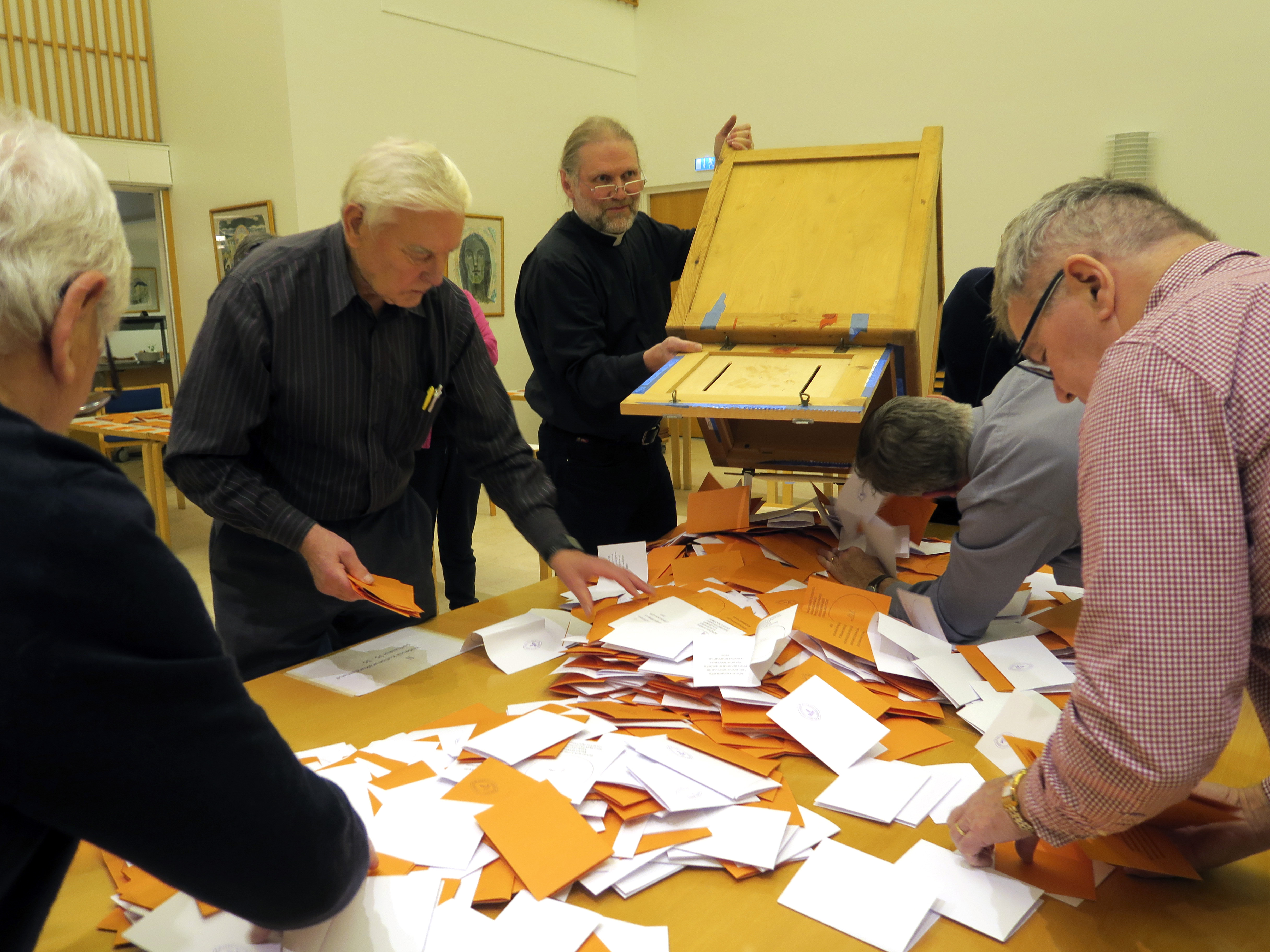 Vaalivirkailijat laskevat äänestystuloksia pöydällä olevasta äänestyslipukkeiden kasasta.