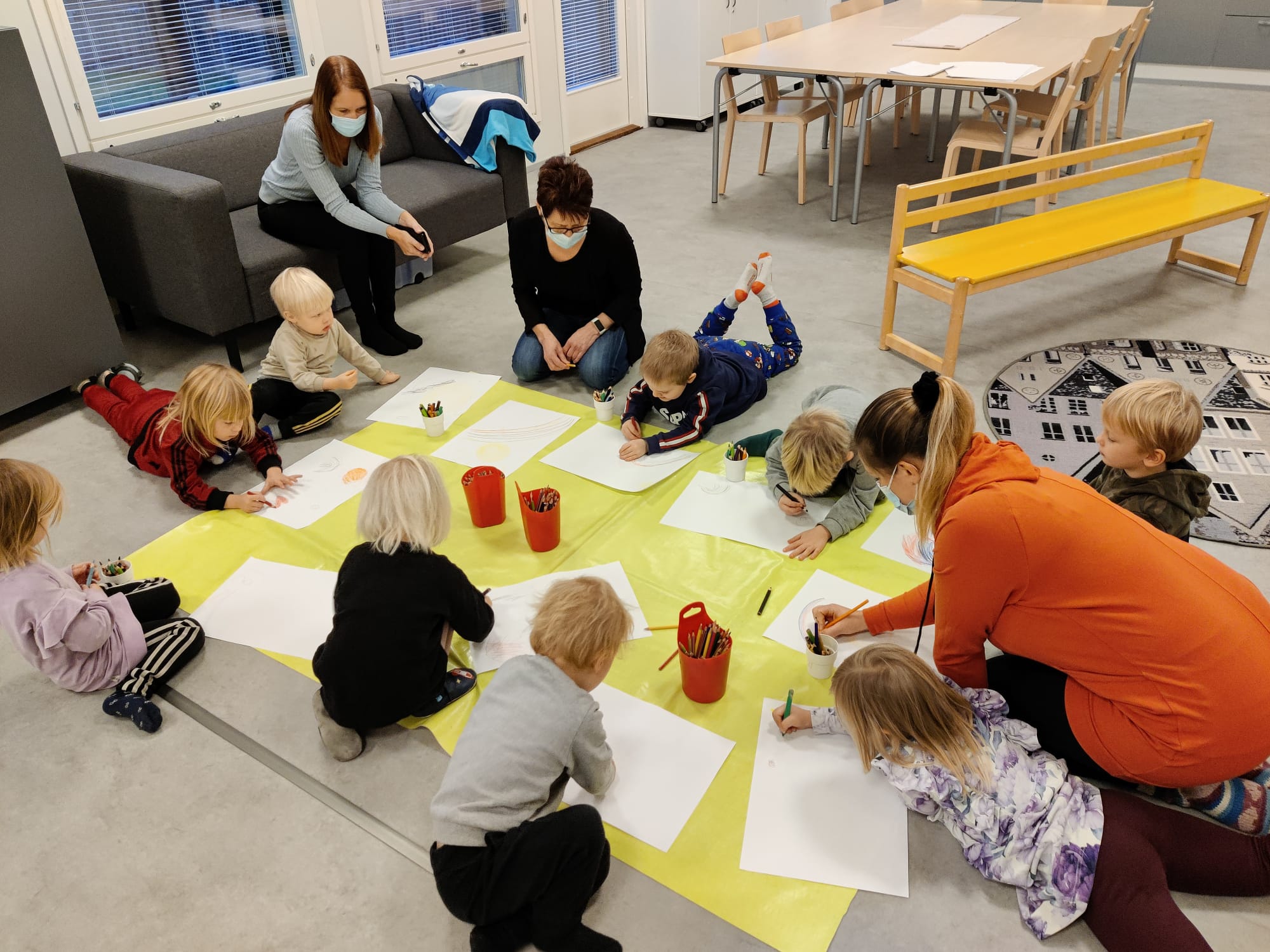 Lapset piirtävät kuvia mattoa varten.